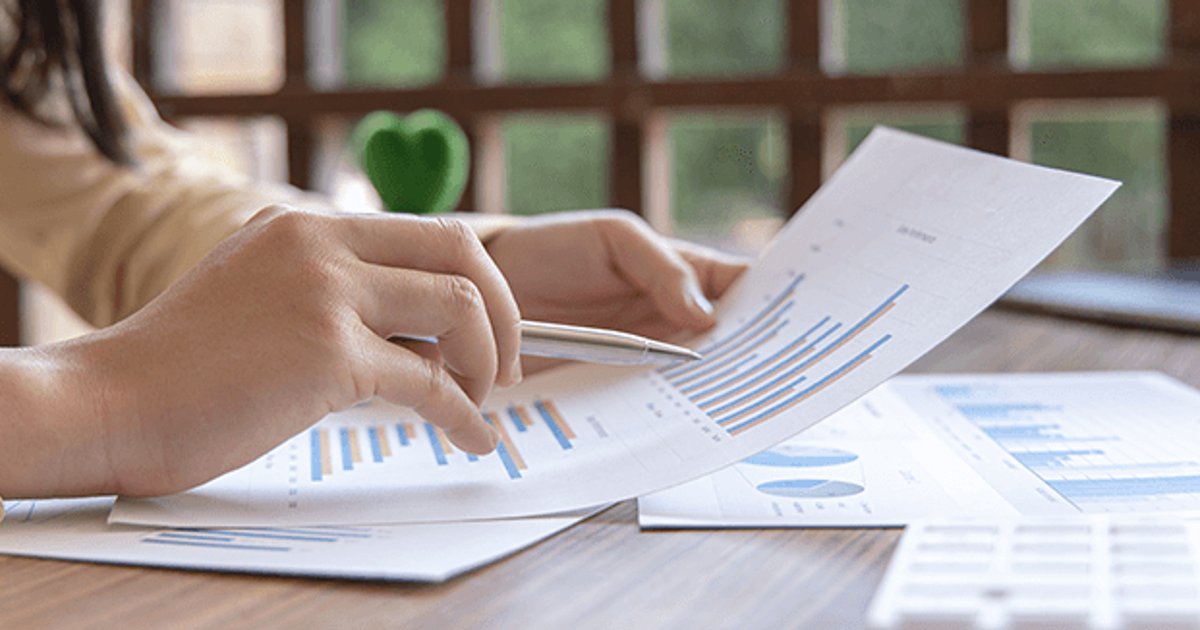 Professional preparing a finance job application in India with resume and laptop